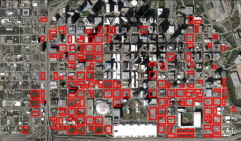 A picture of downtown Houston, with parking lots outlined in red.